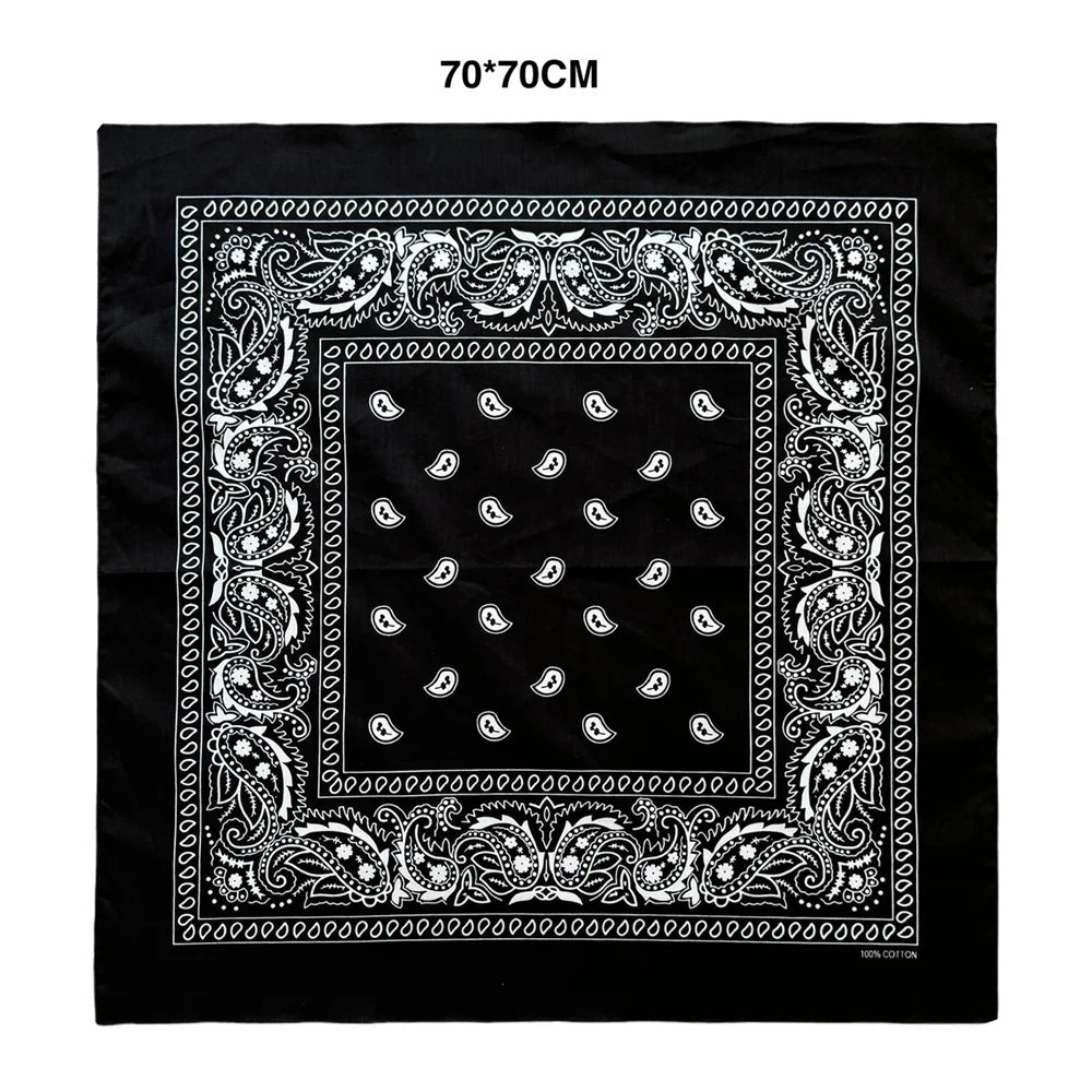 Black fabric with an ornate white paisley border and pattern on a square piece of cloth