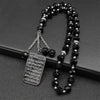 A black beaded necklace with a stainless steel Quran Arabic car pendant charm.