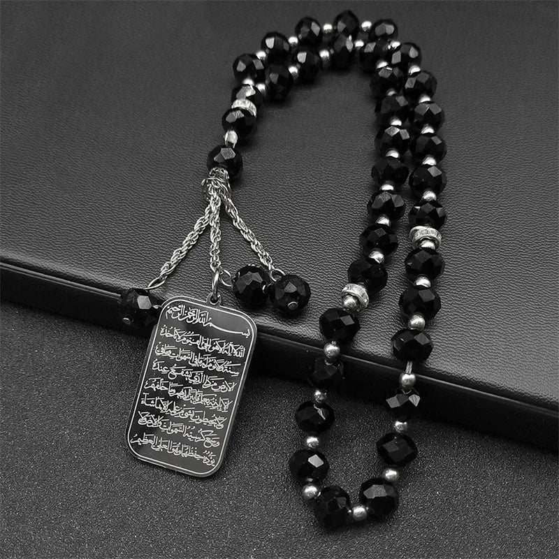 A black beaded necklace with a stainless steel Quran Arabic car pendant charm.