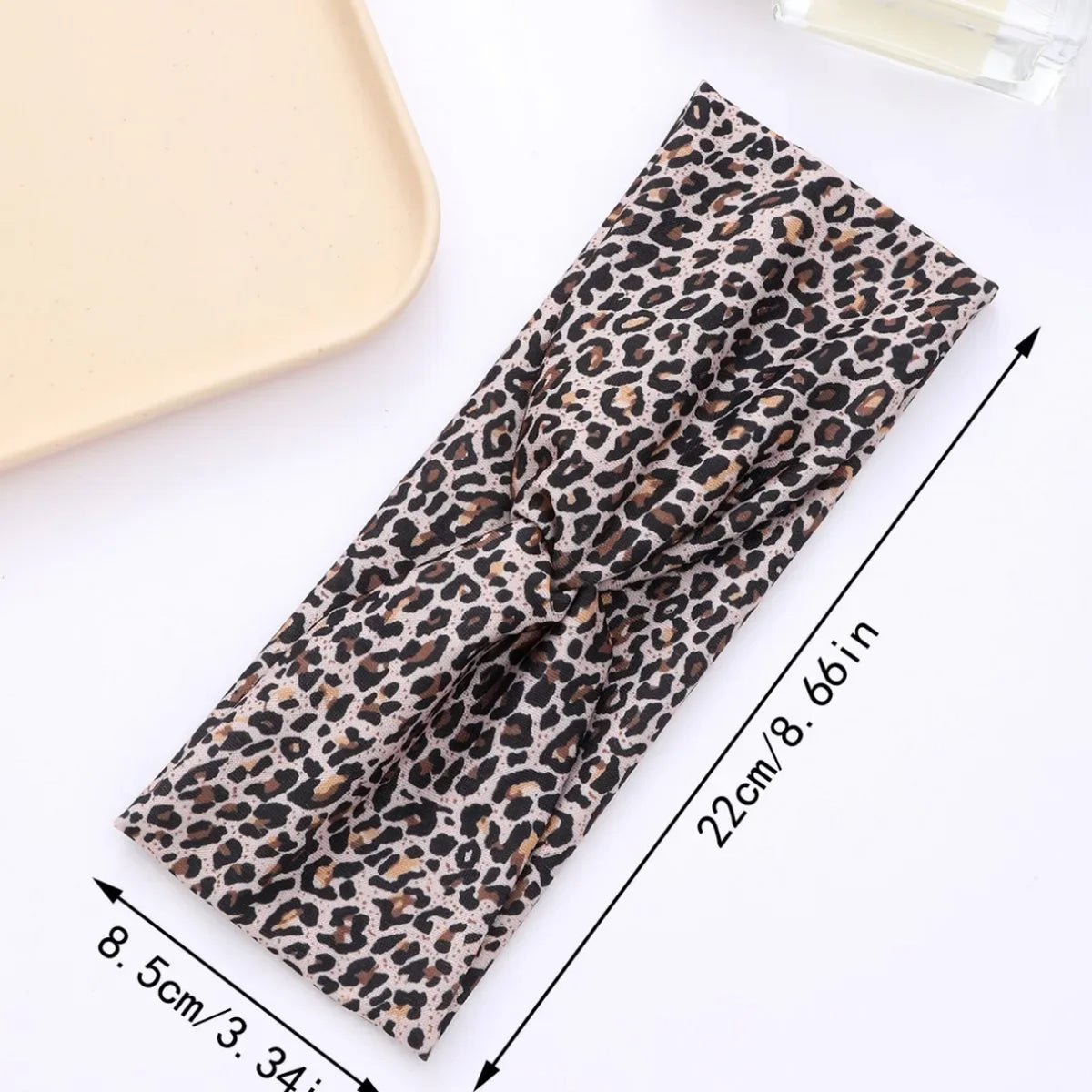 A black and brown leopard print fabric headband is shown flat with measurements.