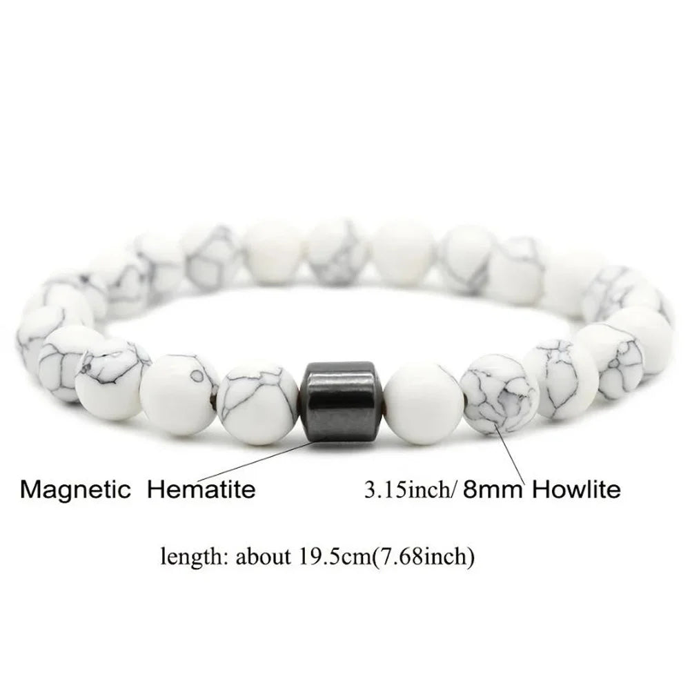 A bracelet made of white and black marbled hematite beads with a black howlite spacer.