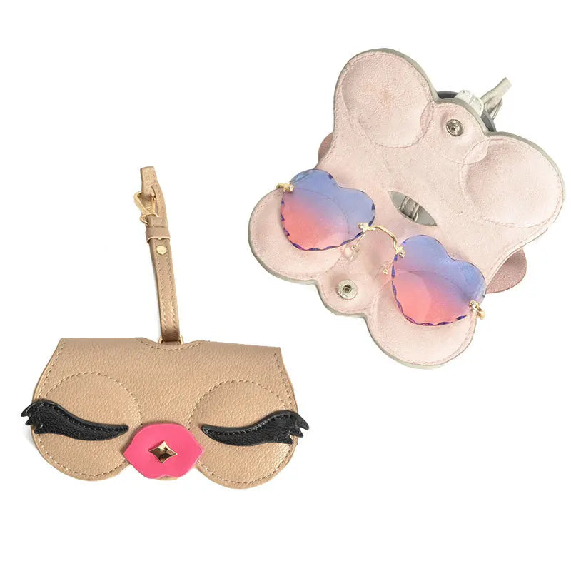 A light pink pouch with a cat face design holds a pair of purple-tinted sunglasses.