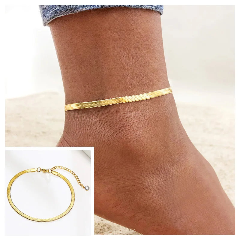 Gold stainless steel snake chain anklet worn on a woman's ankle.