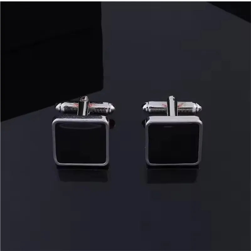 Une paire de boutons de manchette carrés rayés classiques pour hommes avec des pierres d'onyx noir et métal argenté.