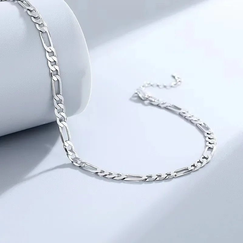 Bracelet pendentif en forme de cœur en argent sterling 925 sur une surface blanche.