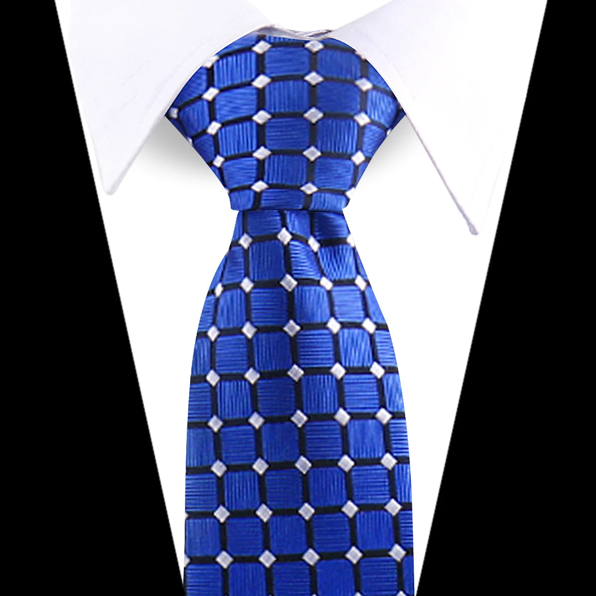 Blue silk necktie with a geometric pattern worn under a white dress shirt.