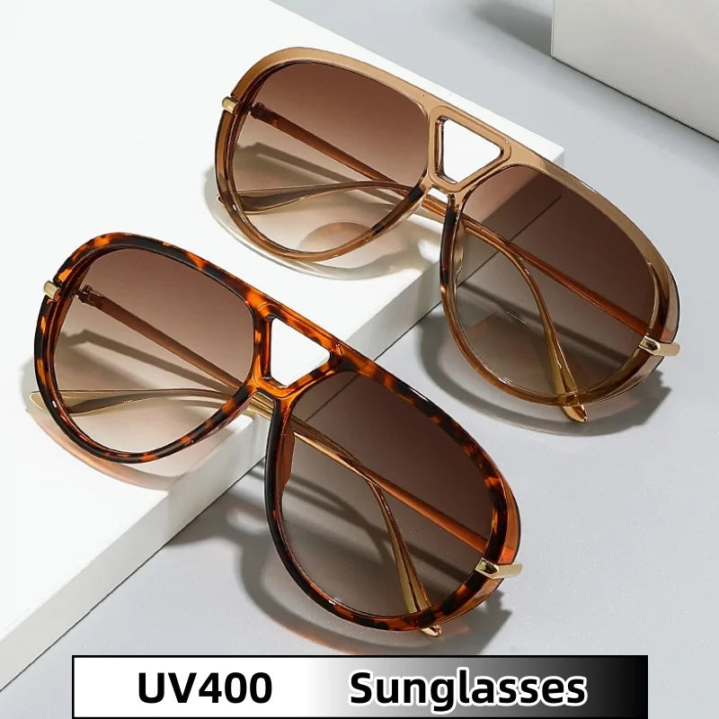 Brown tortoiseshell aviator style sunglasses resting on a white surface.