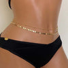 Gold layered metal belly chains worn around the waist of a model.