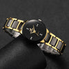 A black and gold couple's analog quartz watch set resting on a dark surface.