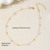 Collier délicat en alliage d'or avec de petites perles blanches, présenté sur fond clair.