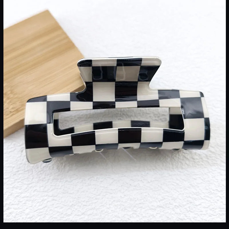 A black and white checkered rectangle hair claw clip resting on a light surface.