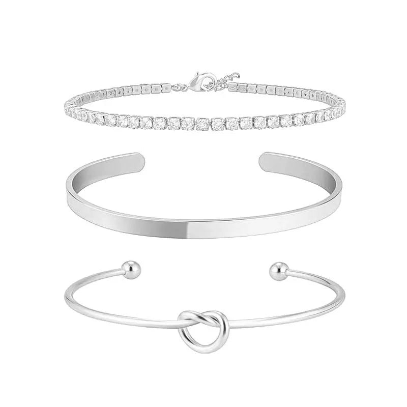 Three gold-plated stainless steel bracelets for women, including a diamond tennis bracelet and two bangle bracelets.