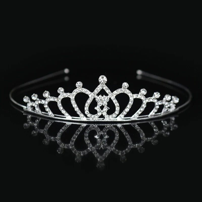 Tiara y corona de princesa de cristal brillante para el cabello, mostradas sobre una superficie oscura.