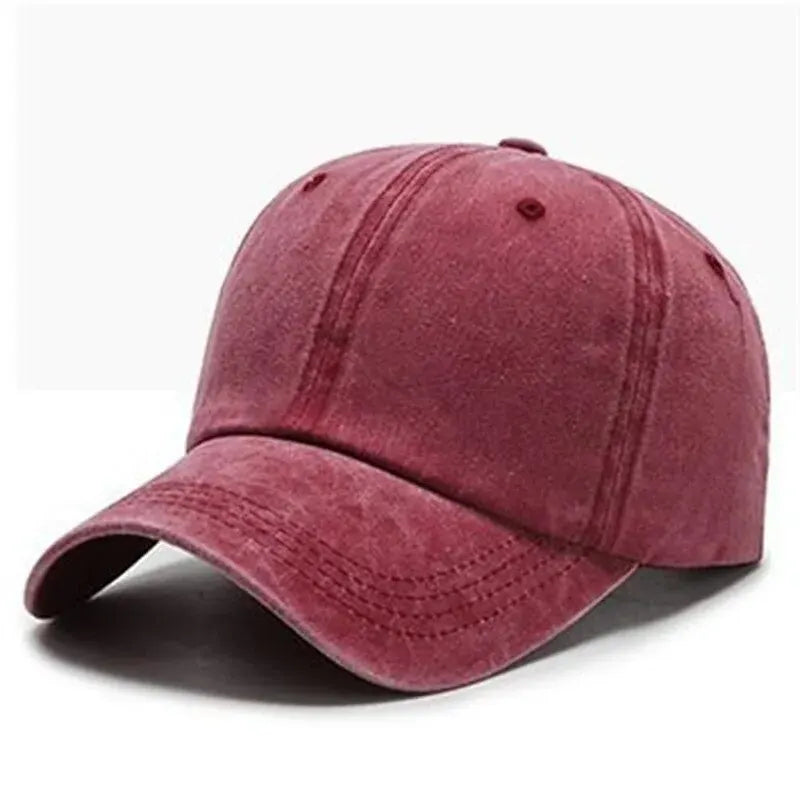 A maroon suede baseball cap shown from the side, featuring a curved brim and a mesh back.