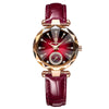 A close-up of an elegant ladies wristwatch with a deep red leather strap and gold accents.