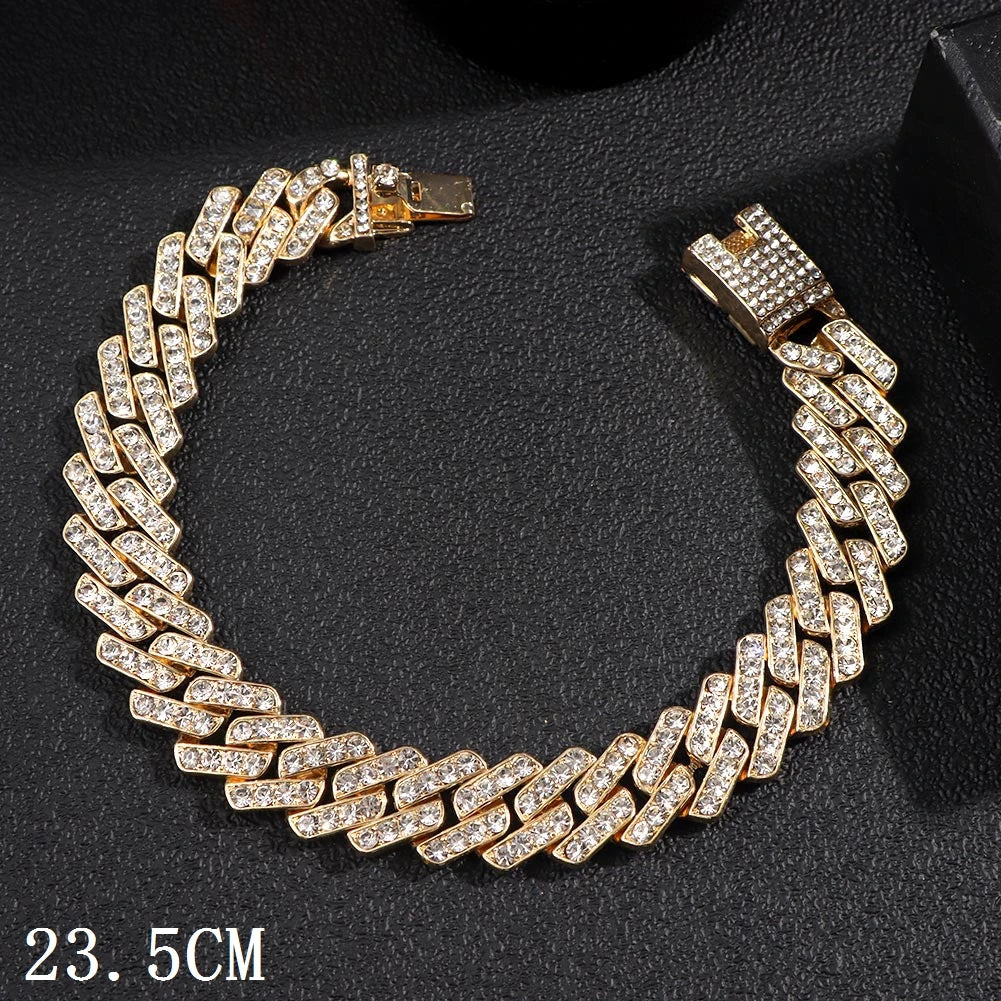 A gold crystal Cuban link anklet bracelet with a silver clasp displayed on a dark background.