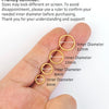Eine Hand demonstriert verschiedene Innendurchmesser von Nasenringen, zwischen 6 mm und 12 mm.