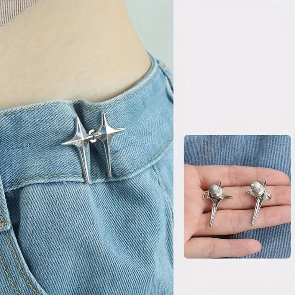 A pair of silver star-shaped decorative buttons fastened onto a denim fabric.