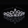 A sparkling crystal hair crown for women displayed on a reflective surface.