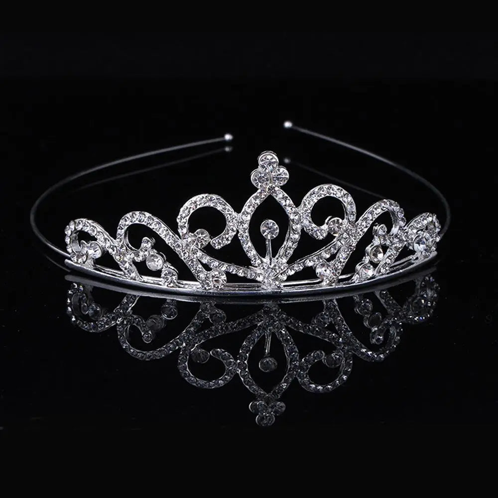 A sparkling crystal hair crown for women displayed on a reflective surface.