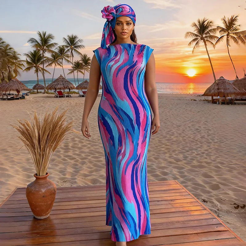 A plus size model wearing a vibrant blue and pink striped maxi dress on a wooden deck with a tropical sunset background.