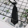 A black classic chain necktie accessory is displayed against a grid background with floral and natural imagery.