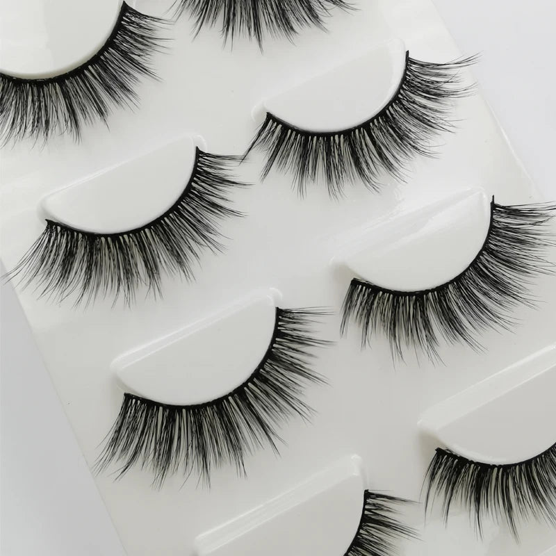 A set of handmade mink strip eyelashes displayed on a white plastic tray.