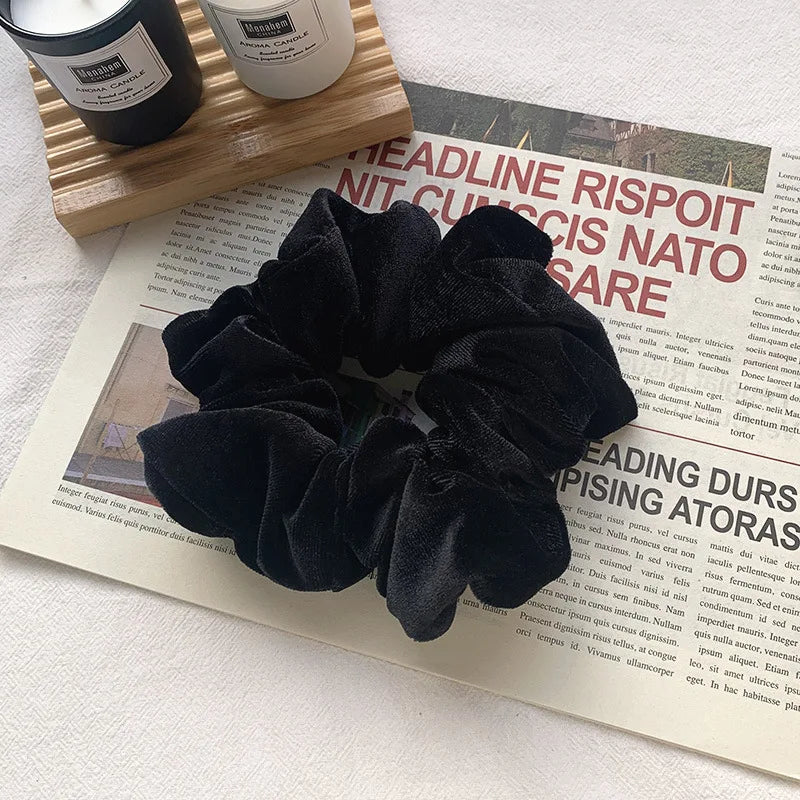 Black velvet heatless hair curling scrunchie displayed on a magazine page.