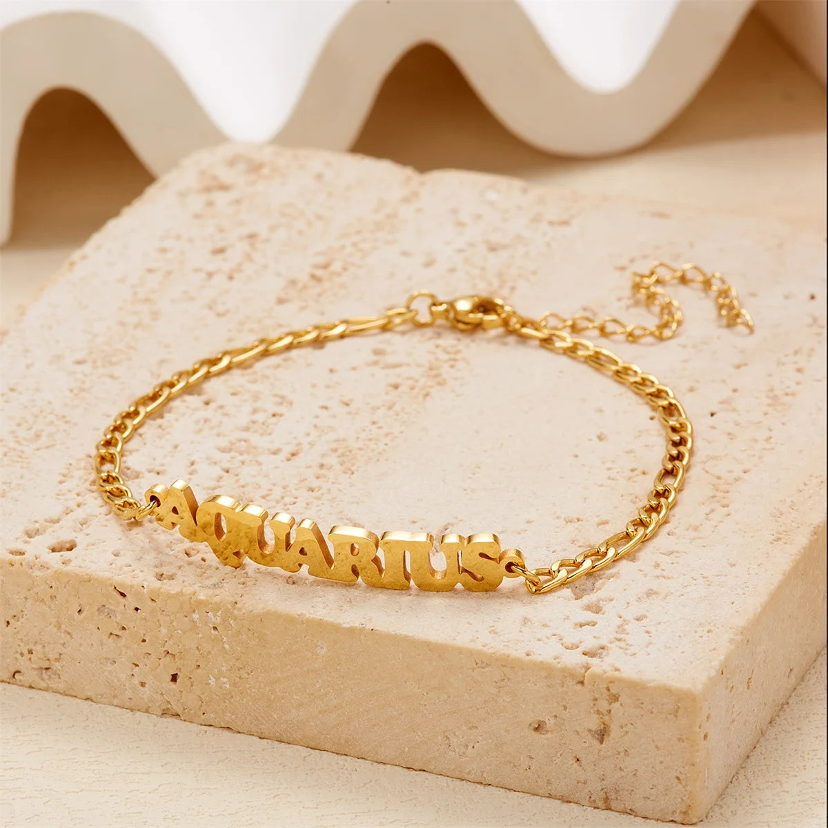 Gold stainless steel constellation charm bracelet featuring the Aquarius zodiac sign on a light background.
