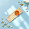 A striped orange and white fabric headband with a round orange button is displayed on a light blue background surrounded by s