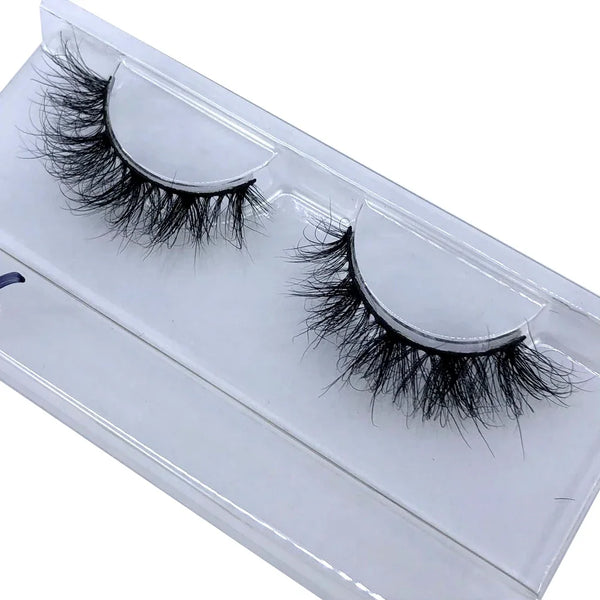A pair of black natural mink false eyelashes displayed in a white cosmetic case.