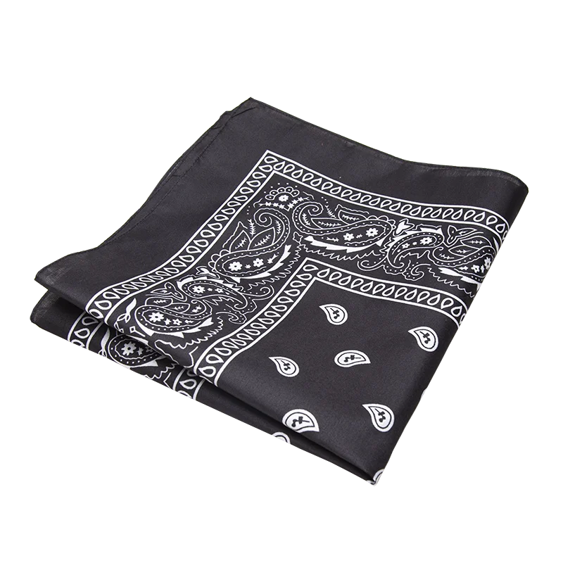 Pañuelo de moda negro doblado con patrones paisley y florales blancos.