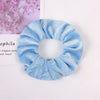 Light blue velvet scrunchies for hair ties shown against a white background.