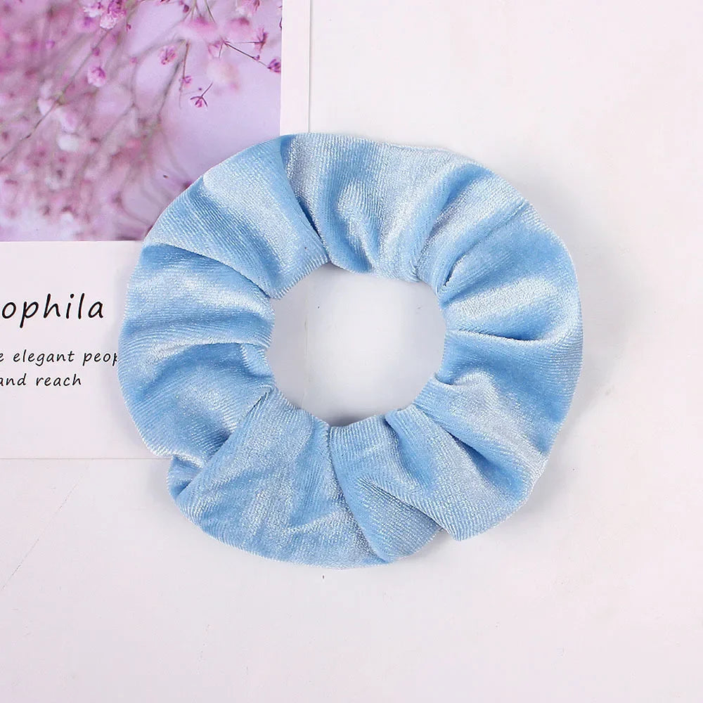 Light blue velvet scrunchies for hair ties shown against a white background.