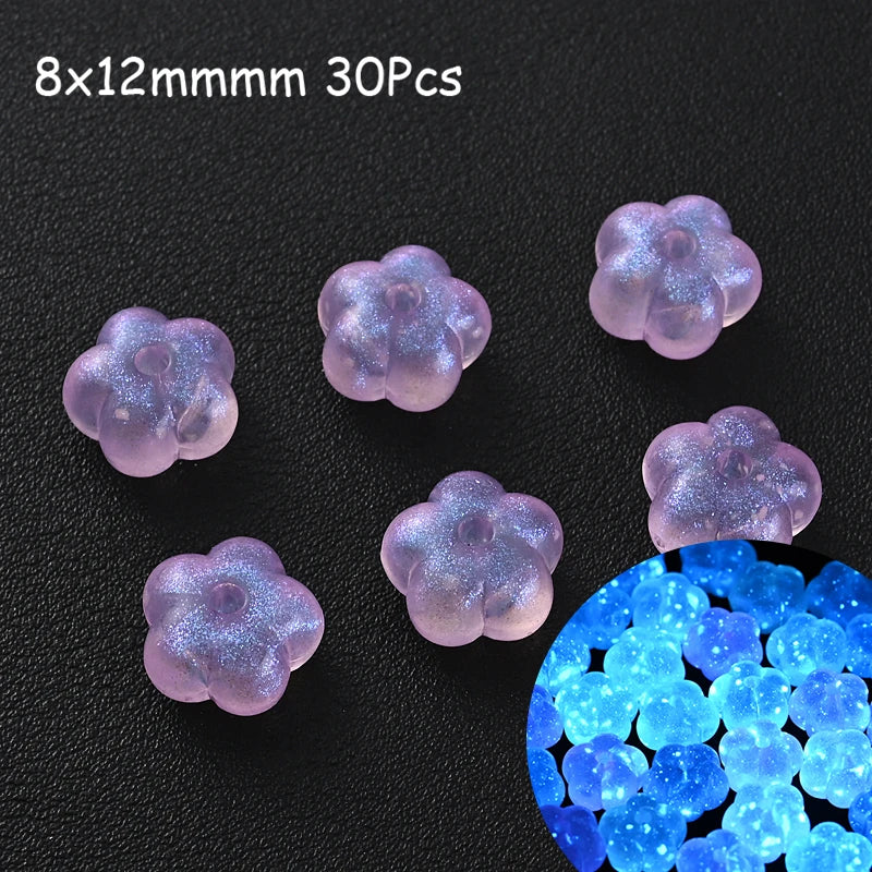 Thirty translucent purple glow-in-the-dark acrylic beads scattered on a dark surface.