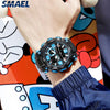 A close-up of a black digital wristwatch with blue accents on a person's wrist, worn against a colorful background.