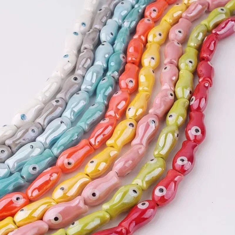 Assortment of ceramic fish charms in various pastel and vibrant colors arranged in a string.