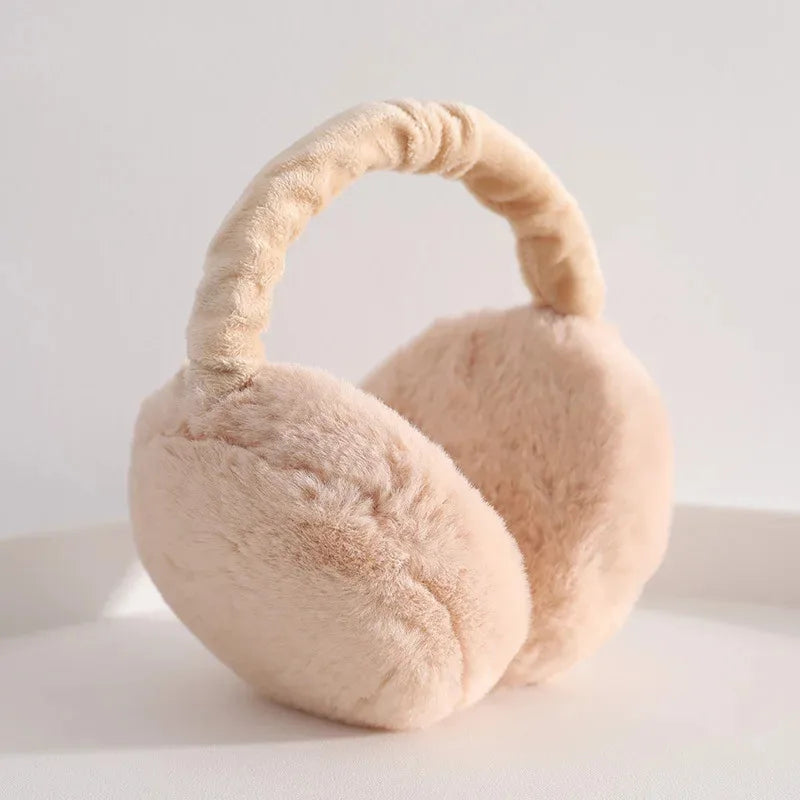 A light beige plush fur ear warmer with a curved ear design.