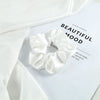 A white satin scrunchie is displayed on a white background with text about beautiful mood.