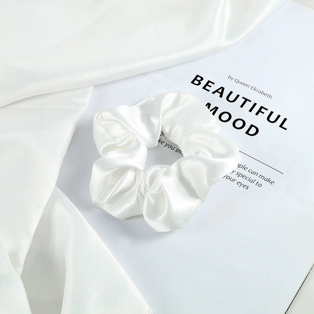 A white satin scrunchie is displayed on a white background with text about beautiful mood.