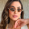 Une femme modélise des lunettes de cat-eye vintage avec une monture écaille et des accents dorés.