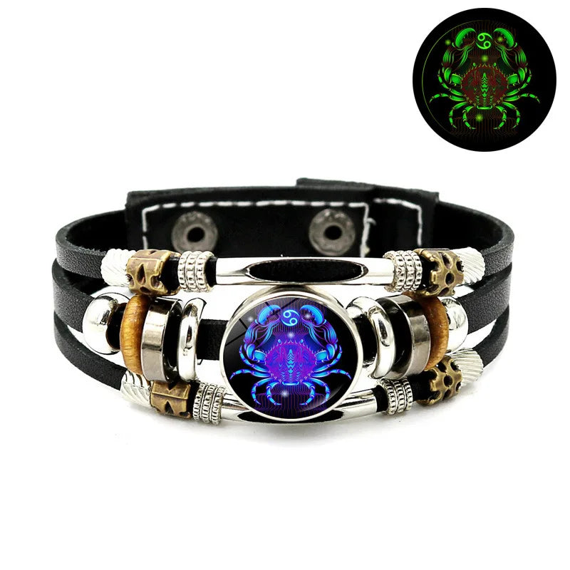 Schwarzes Lederarmband mit silbernen Perlen, goldenen Akzenten und einem zentralen violetten Edelstein.