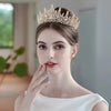 Una mujer vistiendo una elegante diadema de tiara de diamantes barrocos y un vestido blanco.