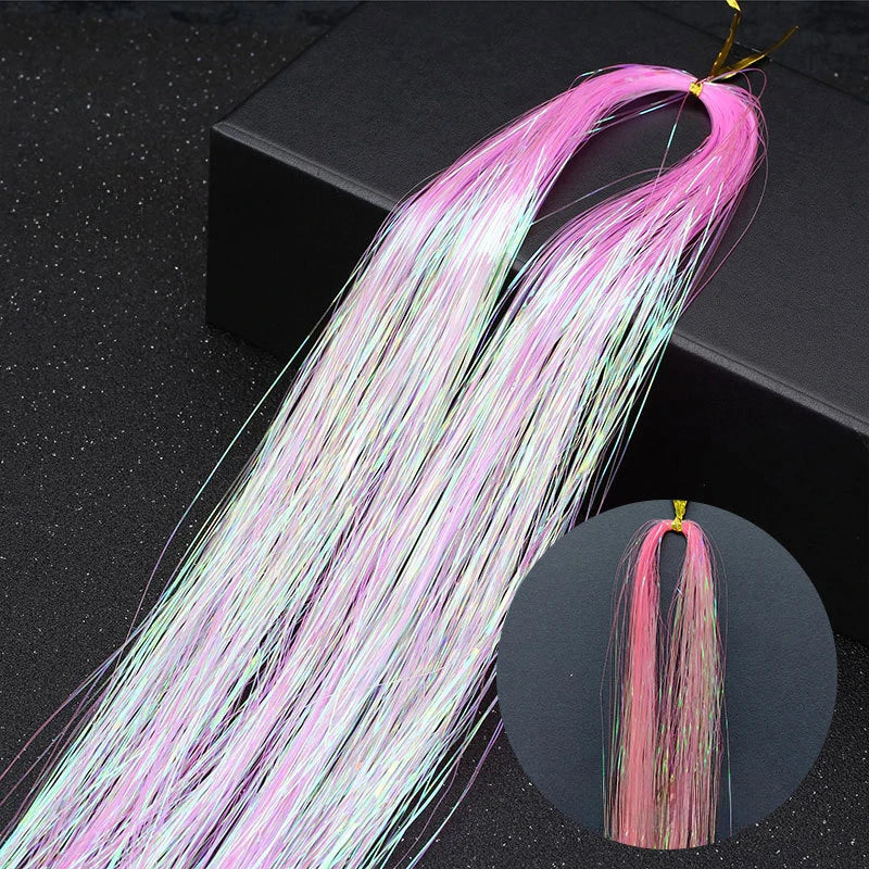 Long pink and white glitter hair extensions strands displayed against a dark background.