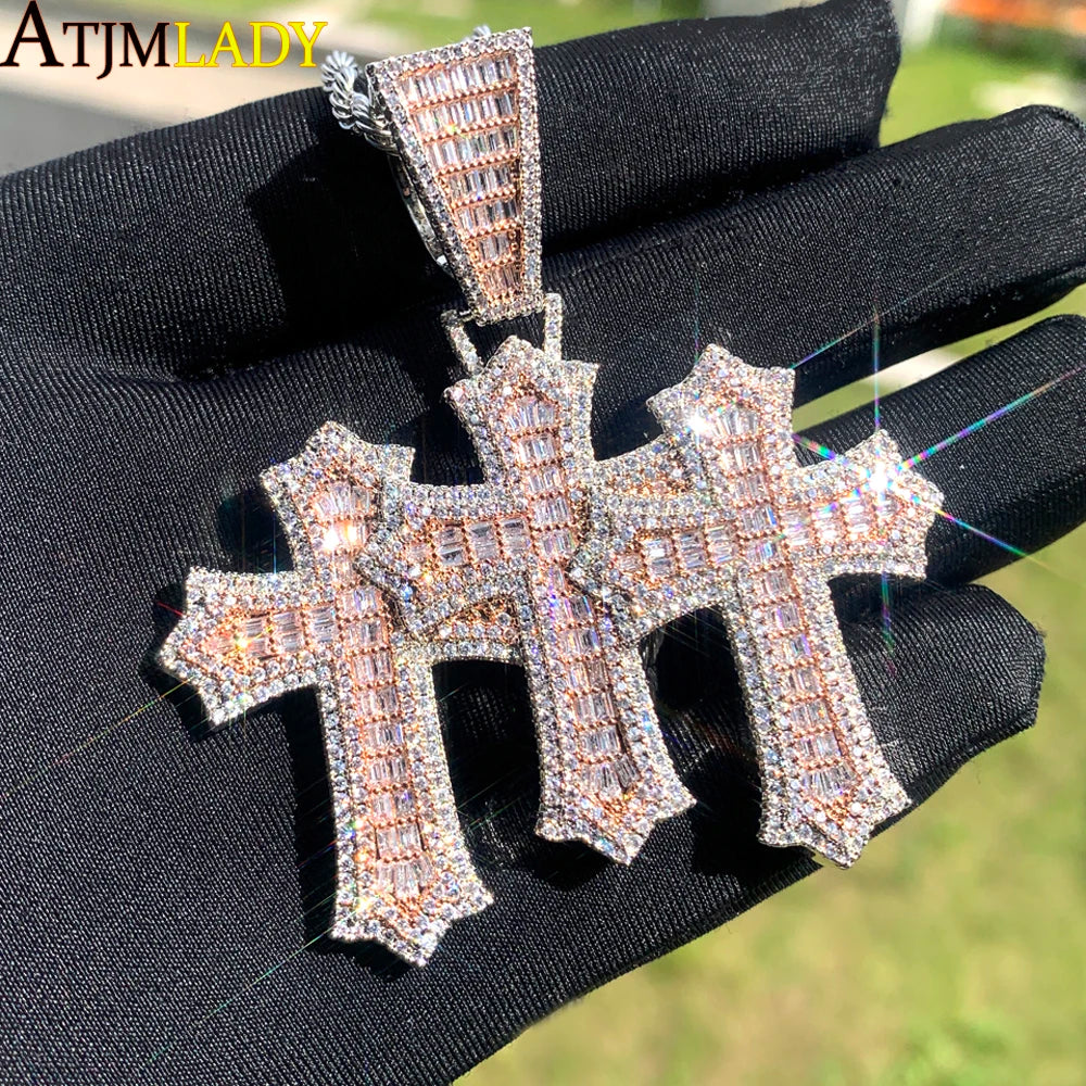 Rapproché d'un pendentif croix serti de glace tenu dans une main contre un fond vert flou.