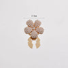 Gold floral button cufflinks featuring small white pearls on a decorative clasp.