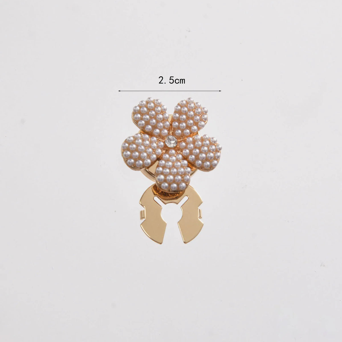 Gold floral button cufflinks featuring small white pearls on a decorative clasp.