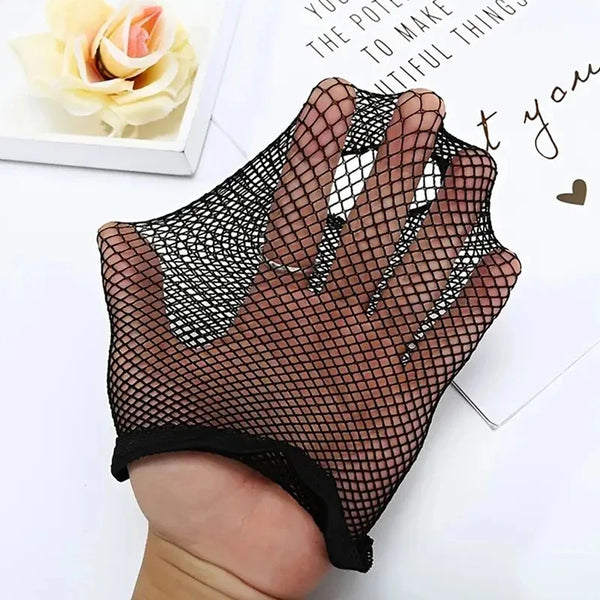A hand is wearing a black fishnet glove or fingerless sleeve on one hand, displayed next to a piece of paper.