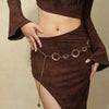 Nahaufnahme einer Frau in einem braunen Kleid mit goldfarbener Metallgürtelverzierung.