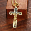 A gold-colored retro Christian cross amulet necklace displayed on a brown wooden box.